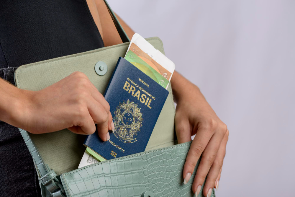 Passaporte brasileiro Mãos colocando o passaporte brasileiro na bolsa feminina verde