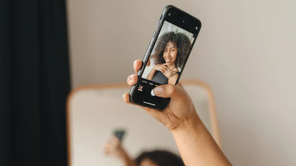 Mulher fazendo selfie com o celular, como no reconhecimento facial da conta gov.br