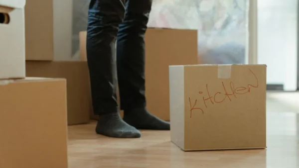 Pessoa entre caixas de mudança em apartamento novo nos EUA